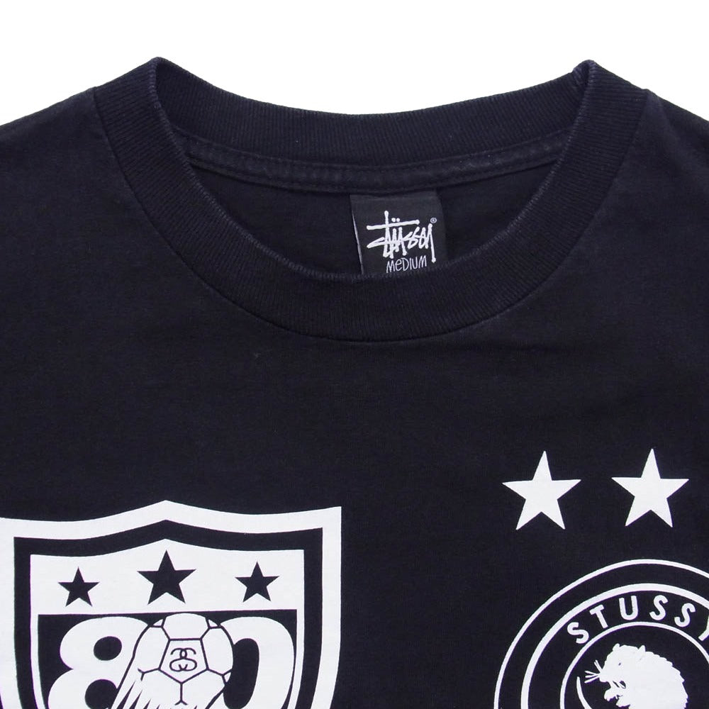 STUSSY ステューシー 【フェイクバスターズ鑑定済】2010 サッカーW杯記念 エンブレム ロングスリーブ 長袖 Tシャツ カットソー ブラック系 M【中古】