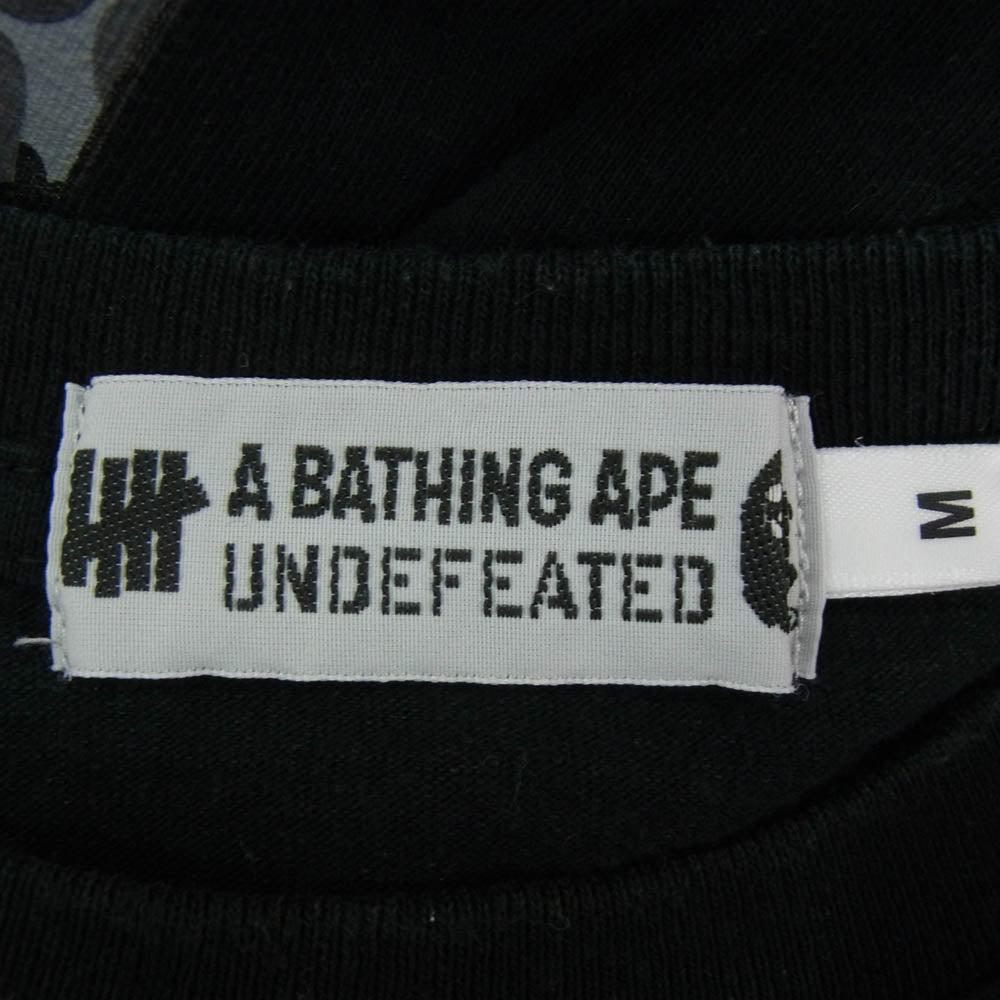 A BATHING APE アベイシングエイプ 001LTG731902X × UNDEFEATED アンディフィーテッド アームマルチ カモ ロゴプリント 長袖 カットソー ブラック系 M【中古】