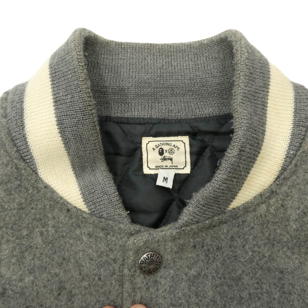 A BATHING APE アベイシングエイプ STUSSY ステューシー 11SS × STUSSY 30周年記念 モデル Varsity jacket ステューシー 袖 レザー サルフェイス SSリンクロゴ ワッペン スタジャン バーシティジャケット グレー系 M【中古】